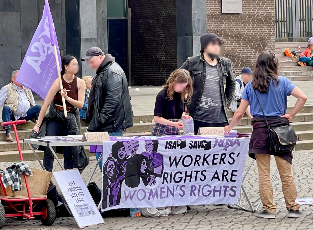 Feministischer Informationsstand auf dem Bremer Marktplatz mit Transparenten für Abtreibungsrechte und die Rechte von Frauen.