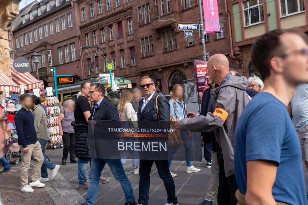 Teilnehmer:innen der Frankfurter Trauerwache hinter einem Transparent mit der Aufschrift Bremen.