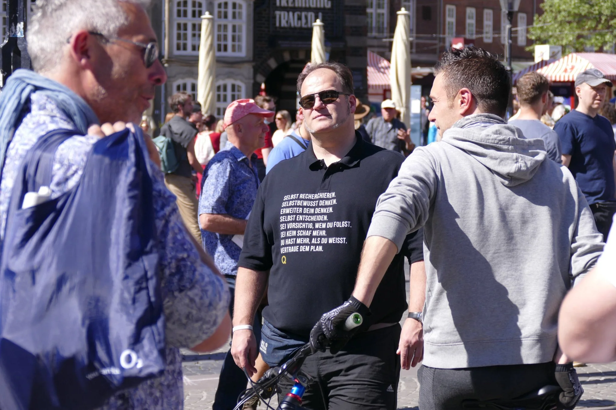 Teilnehmer der Bremer Kundgebung mit QAnon-Aufdruck auf einem schwarzen T-Shirt.