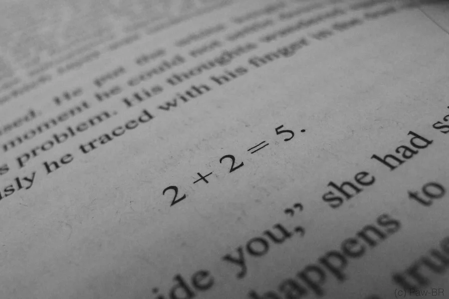 Schwarz-Weiß-Aufnahme einer Buchseite mit der Formel 2 + 2 = 5.