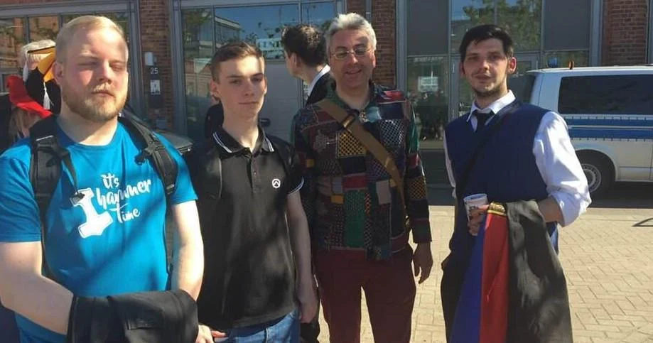 Gruppenfoto beim Delmenhorster Aufmarsch am 5. Mai 2018; auf zwei Oberteilen sind ein Thorshammer-Motiv und das Lambda-Logo der Identitären Bewegung zu sehen.