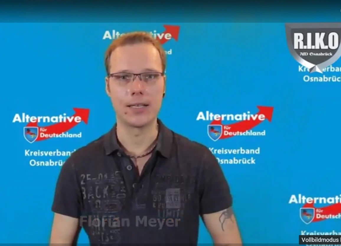 Florian Meyer vor einer Wand mit Logos der AfD Osnabrück; rechts oben das Zeichen von RIKO.