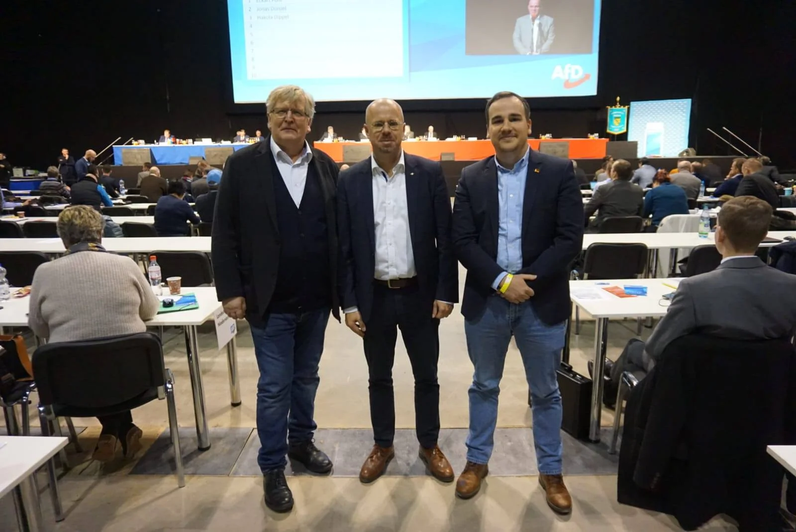 Drei Männer vor der Bühne des AfD-Parteitags in Riesa im Januar 2019. Die Bildunterschrift benennt Lührssen, Kalbitz und Teske.