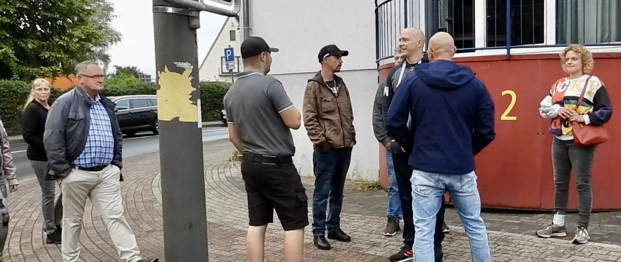 Mehrere Menschen stehen vor dem Veranstaltungsgebäude in Achim am 8. September 2022.