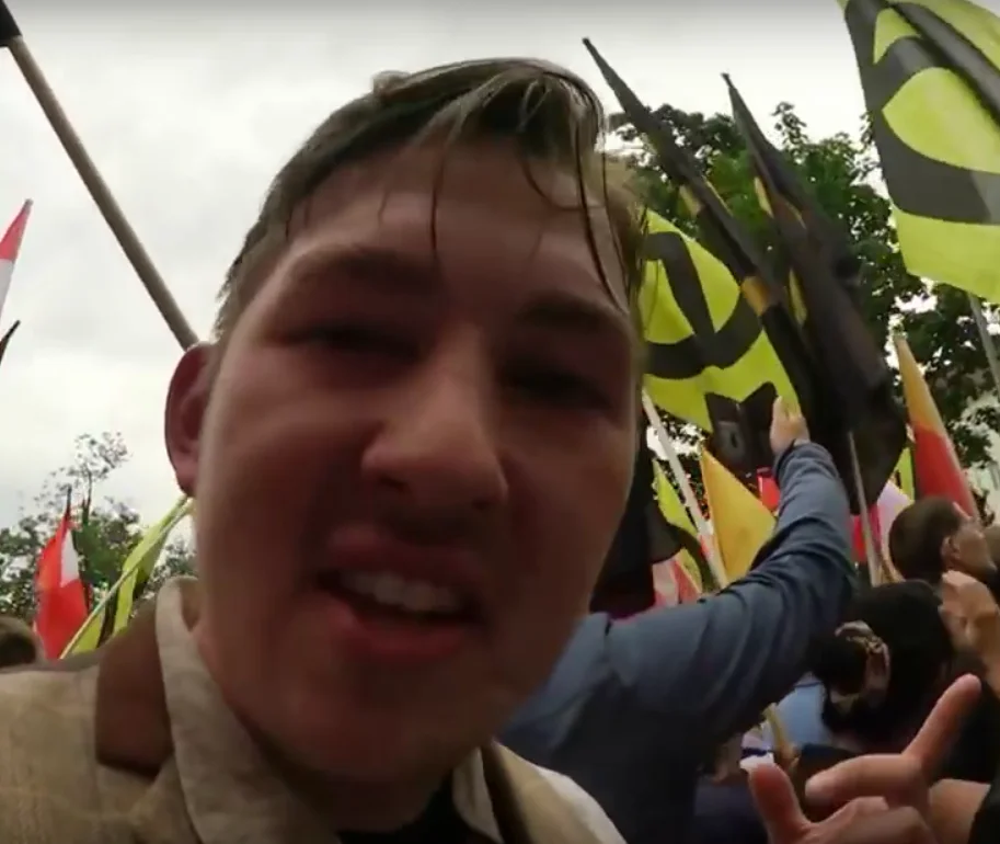 Lars Steinke in einem Video von 2016; hinter ihm sind Fahnen der Identitären Bewegung zu sehen.