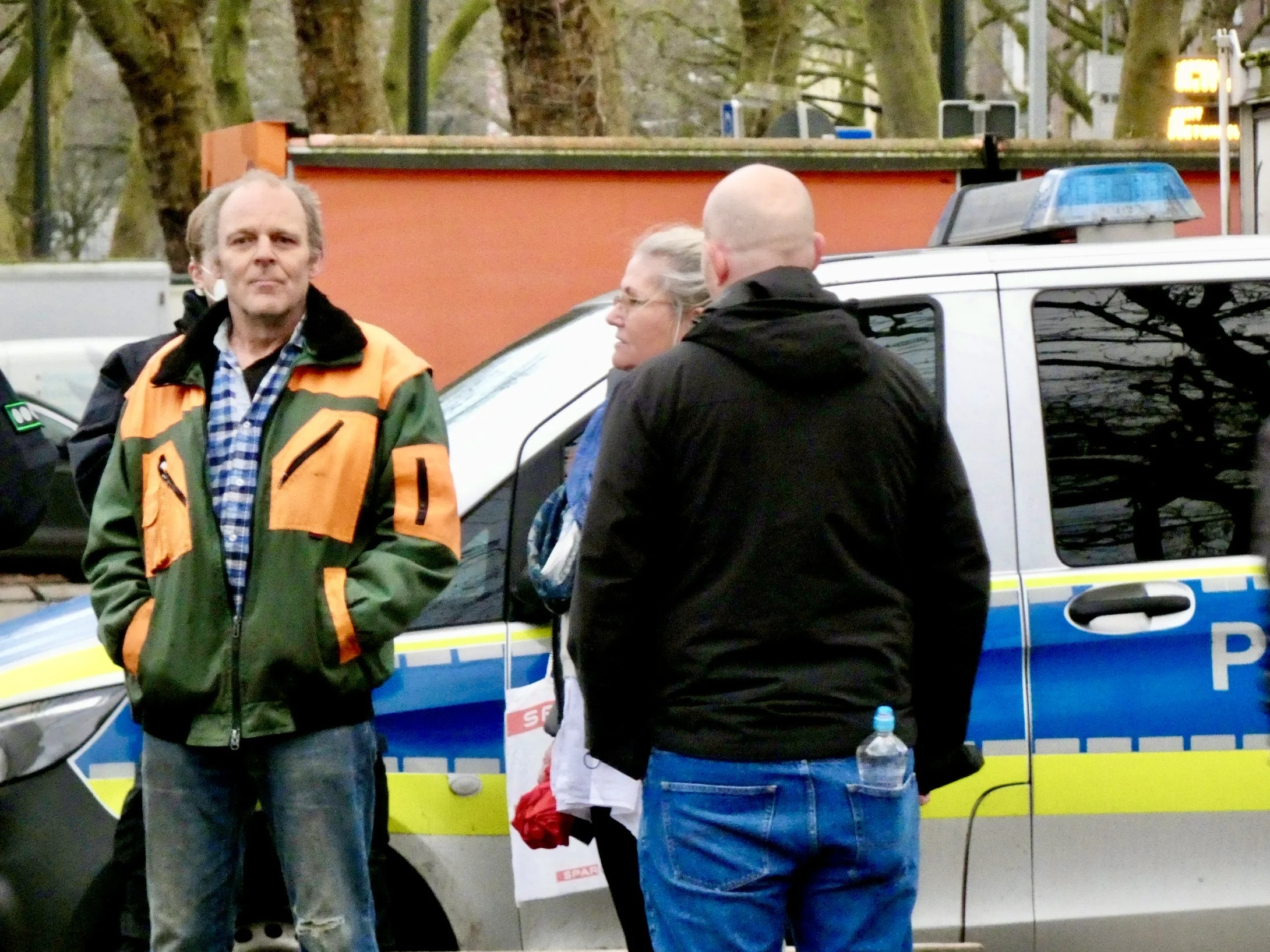 Aufnahme vom Findorffmarkt: mehrere Menschen neben einem Polizeifahrzeug.