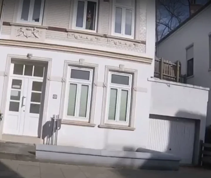Jonas Schick am Fenster der damaligen Büroräume; das Bild verlinkt die archivierte Videoaufnahme.