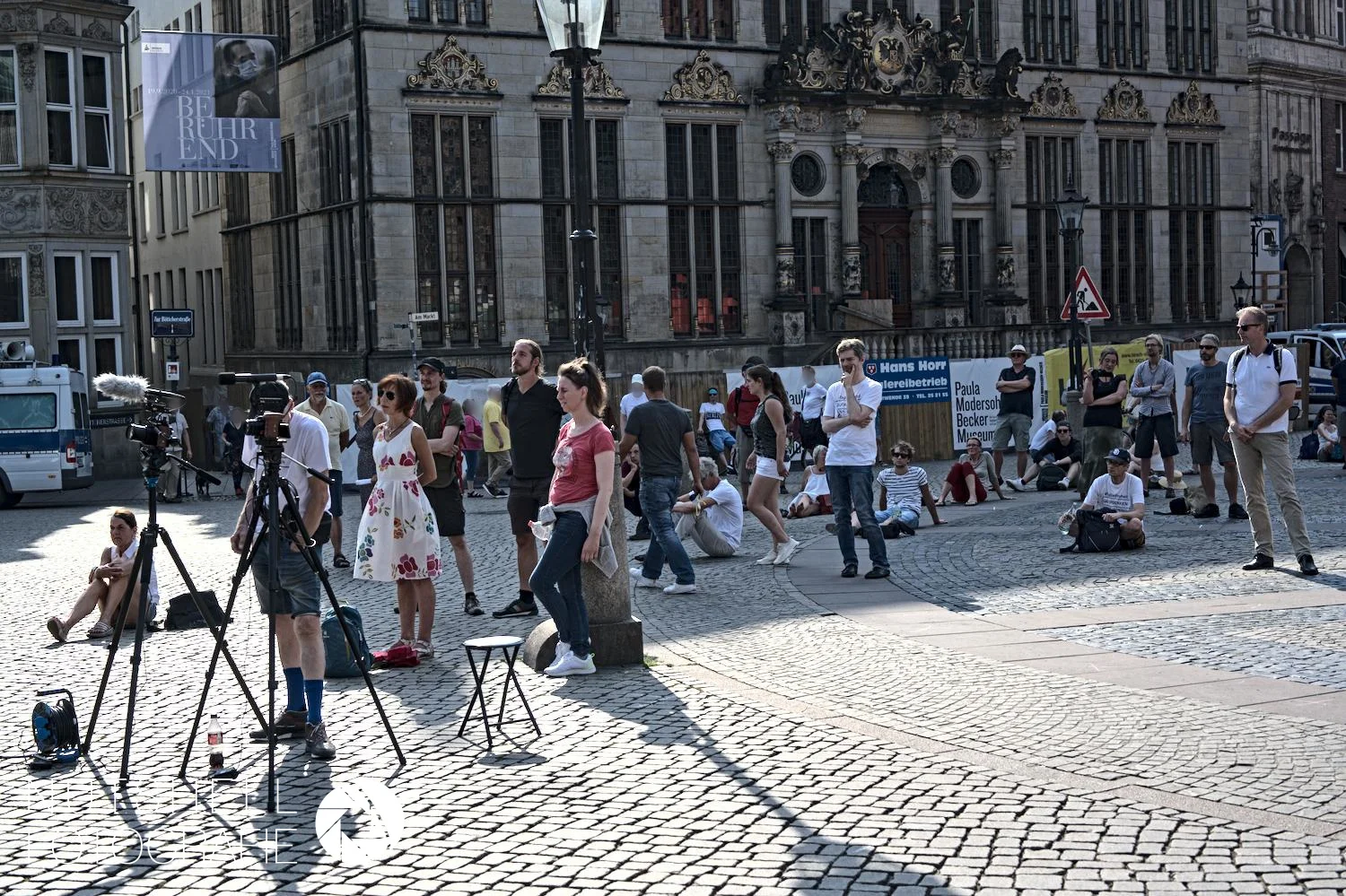 Teilnehmer:innen und Kameras bei einer Kundgebung auf dem Bremer Marktplatz.